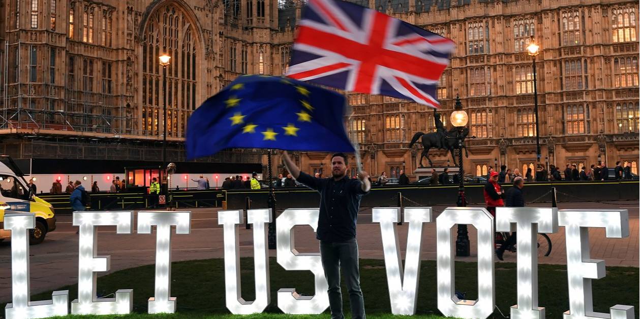 Сторонник второго референдума по Brexit на фоне надписи 