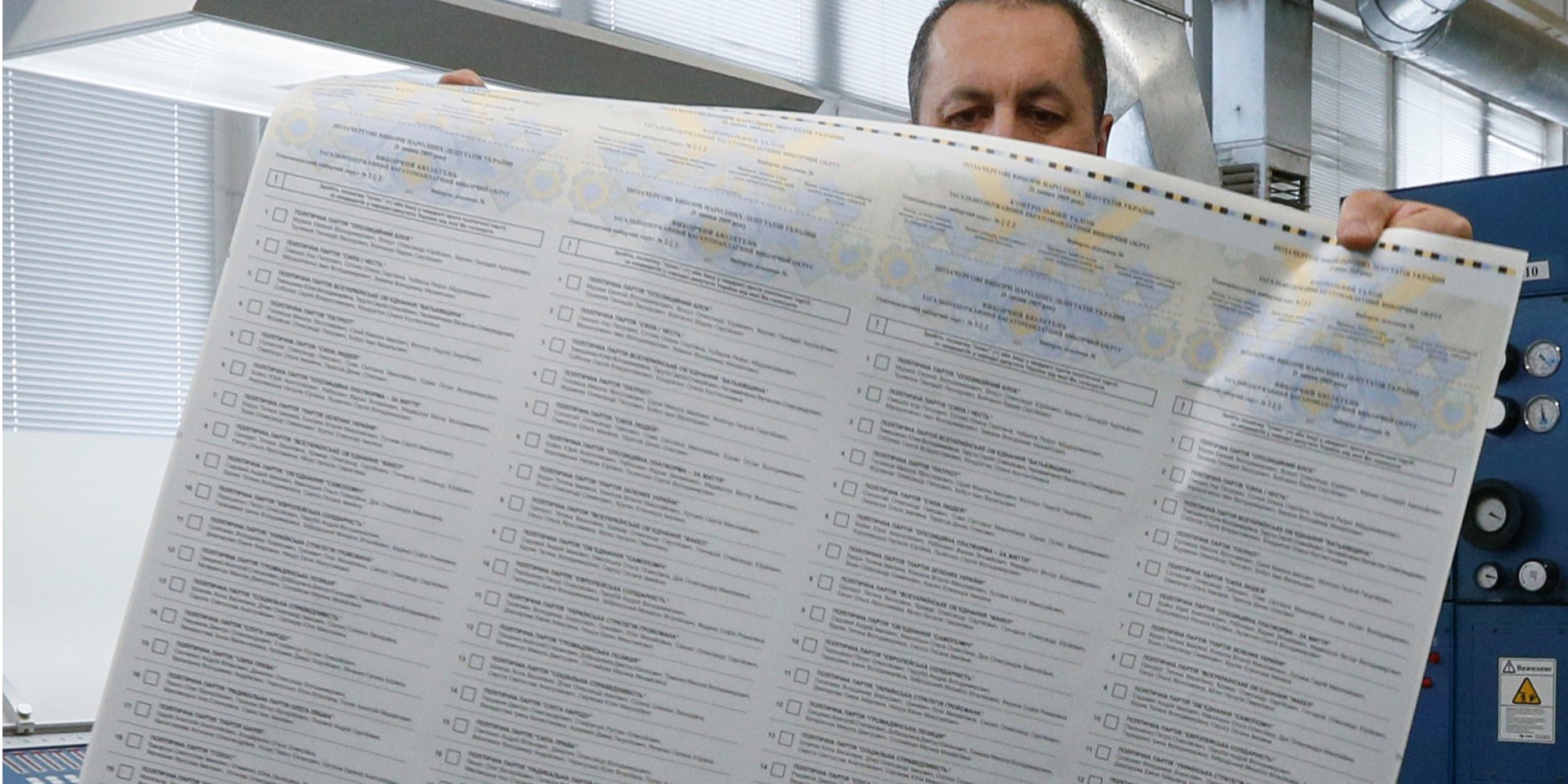 Працівник поліграфкомбінату Україна демонструє бюлетень зі списком партій (Фото: REUTERS / Valentyn Ogirenko)