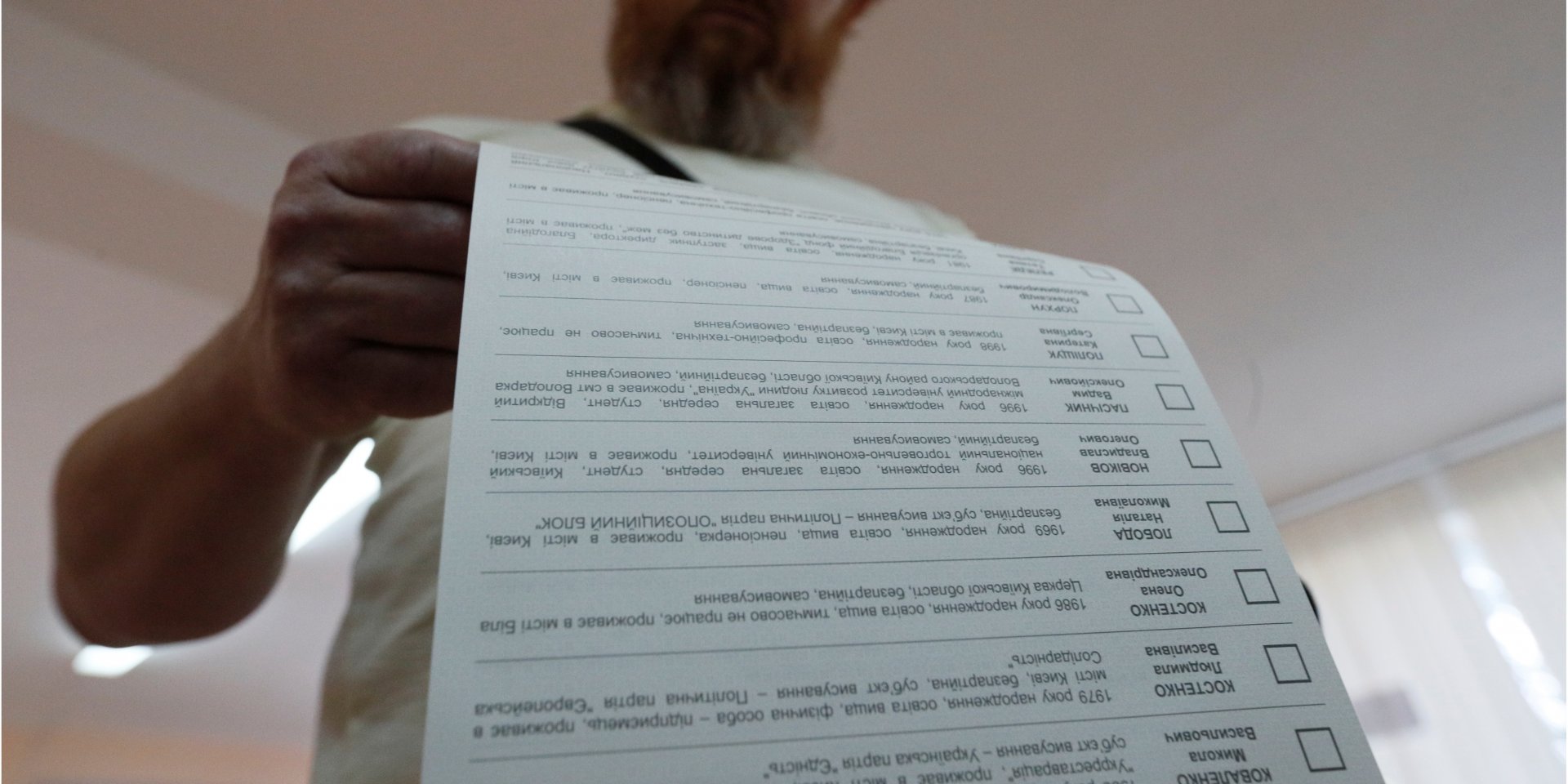Избиратель просматривает бюллетень на избирательном участке во время парламентских выборов. Киев, 21 июля (Фото: REUTERS/Valentyn Ogirenko)