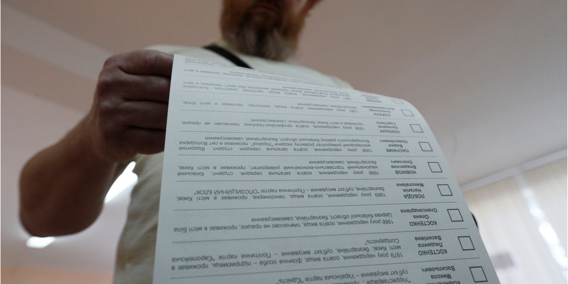 Виборець переглядає бюлетень на виборчій дільниці під час парламентських виборів. Київ, 21 липня (Фото: REUTERS / Valentyn Ogirenko)