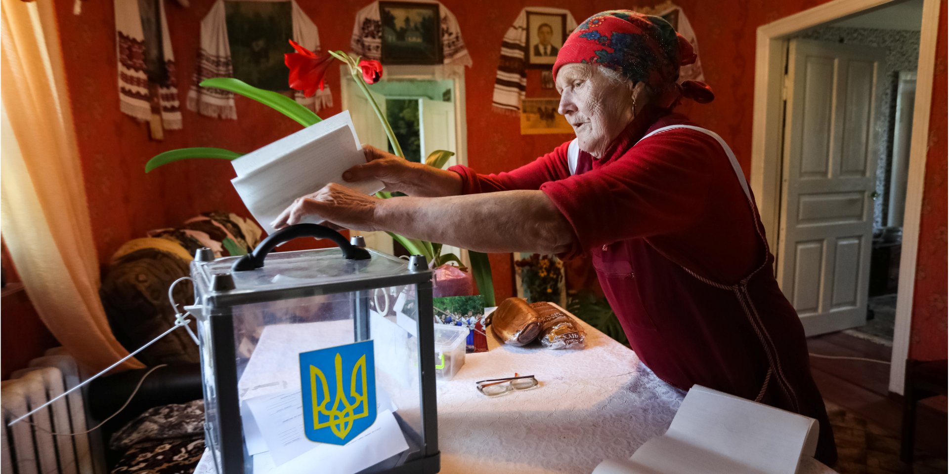 Жінка кидає бюлетень в переносну урну у себе вдома. Бугаївка, Київська область, 21 липня 2019 року (Фото: REUTERS / Konstantin Chernichkin)