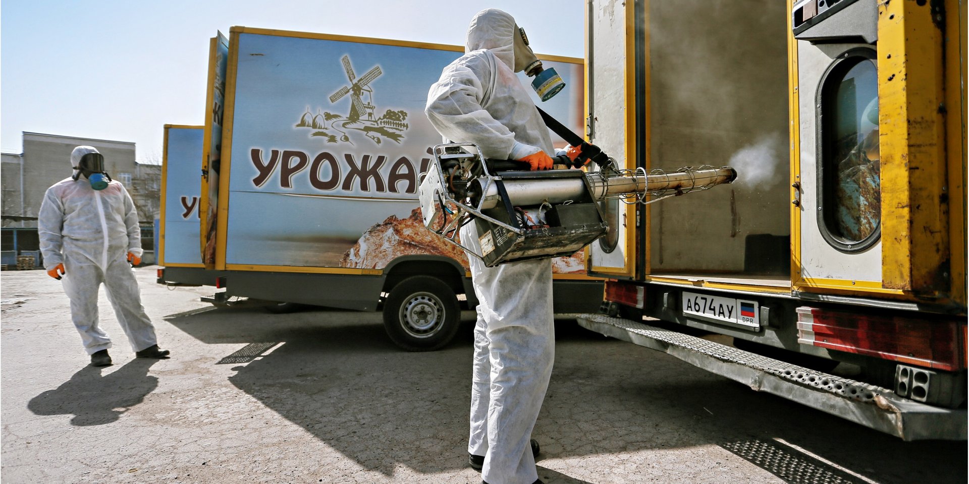 Спеціаліст в захисному костюмі обробляє розвізні автомобілі в одній з пекарень Донецька (17 березня) (Фото: REUTERS / Alexander Ermochenko)