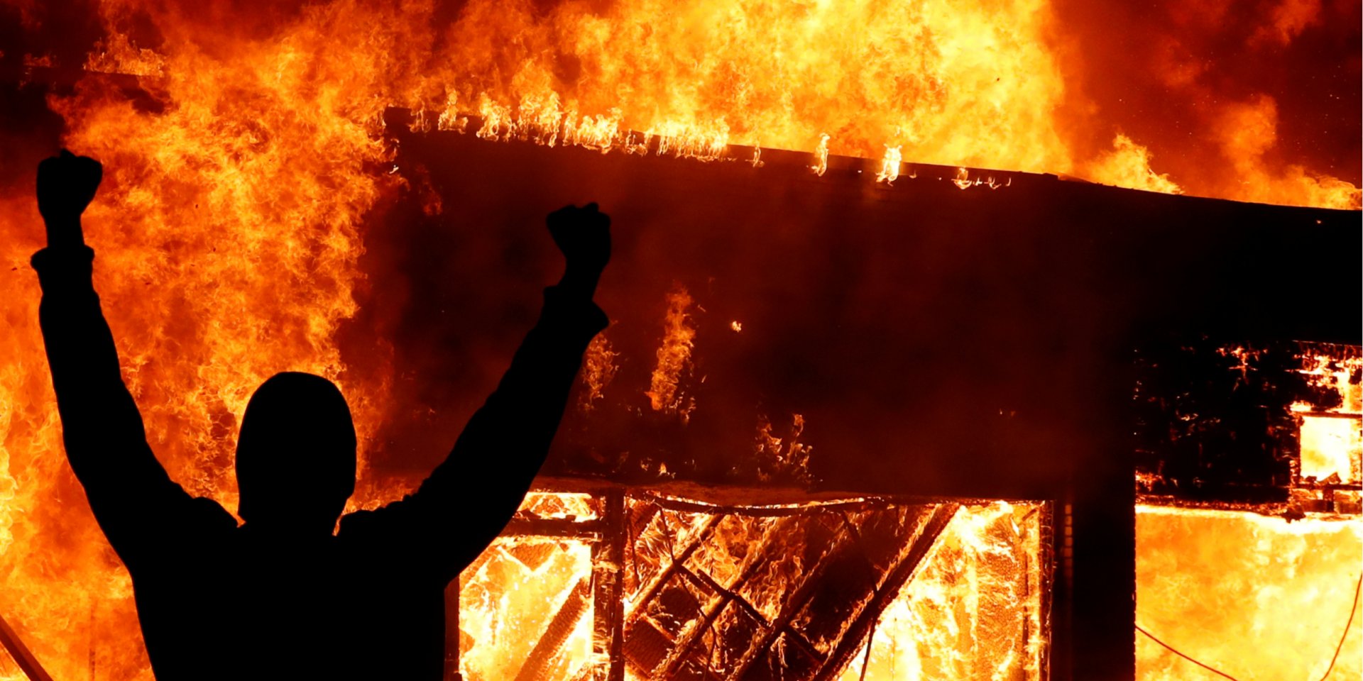 Протестувальник на&nbsp;тлі пожежі у Міннеаполісі (Фото: REUTERS/Lucas Jackson)