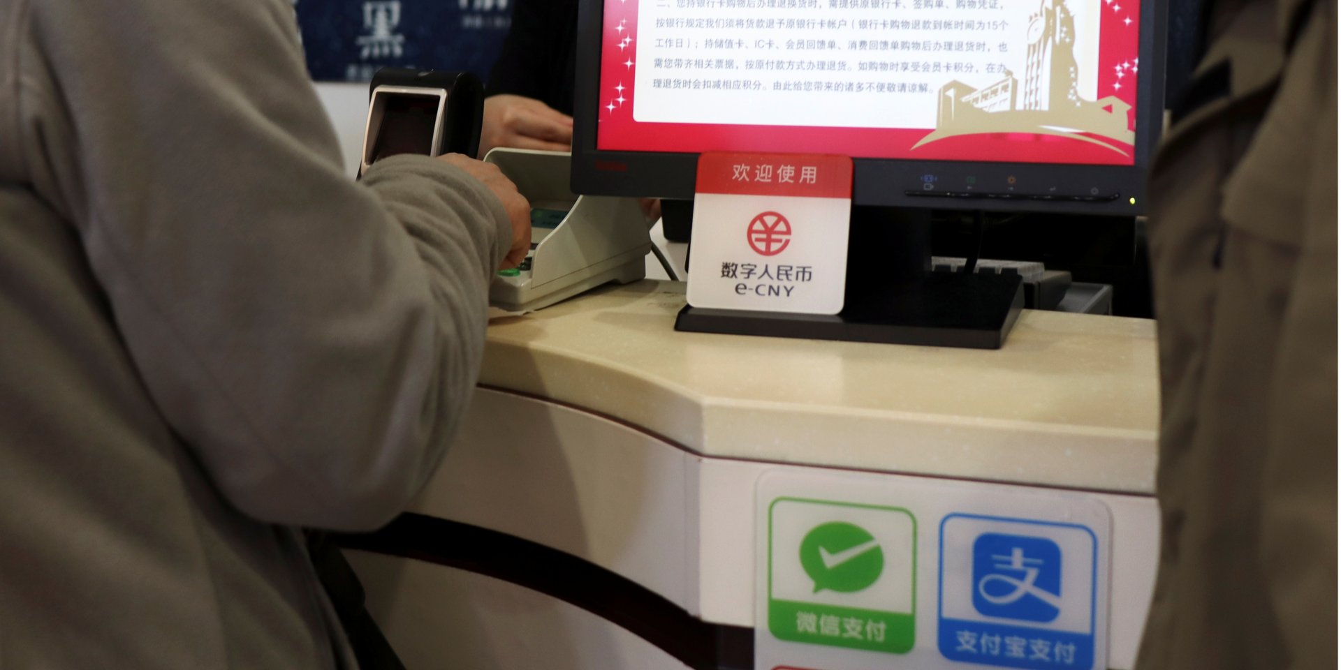 Знак, указывающий на возможность расплатиться цифровыми юанями или e-CNY в пекинском торговом центре (Фото: REUTERS / Florence Lo)