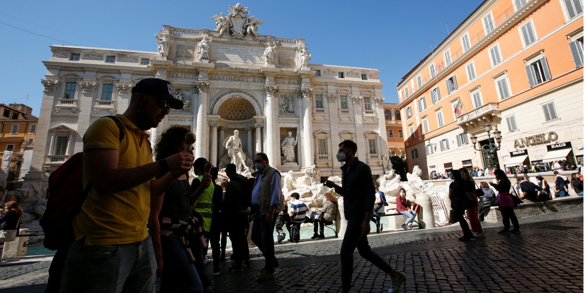 Люди проходят мимо фонтана Треви в Риме (Фото: REUTERS / Remo Casilli)