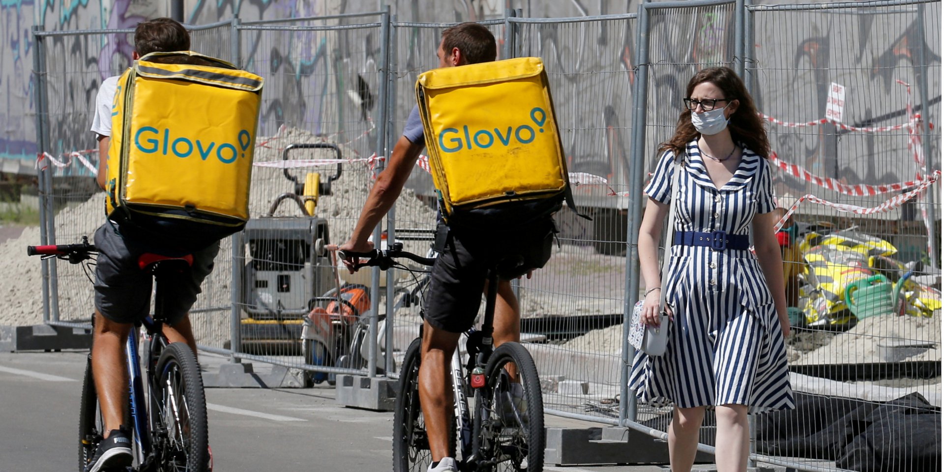 Девушка в защитной маске и курьеры Glovo на улицах Киева во время эпидемии коронавируса (Фото: REUTERS/Valentyn Ogirenko)