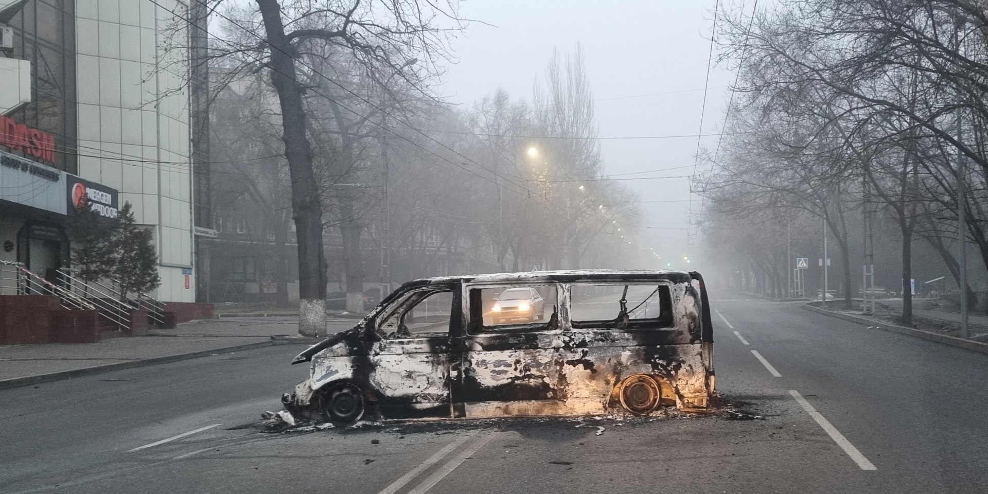 Сгоревший автомобиль посреди дороги в Алматы (Фото: REUTERS/Stringer)
