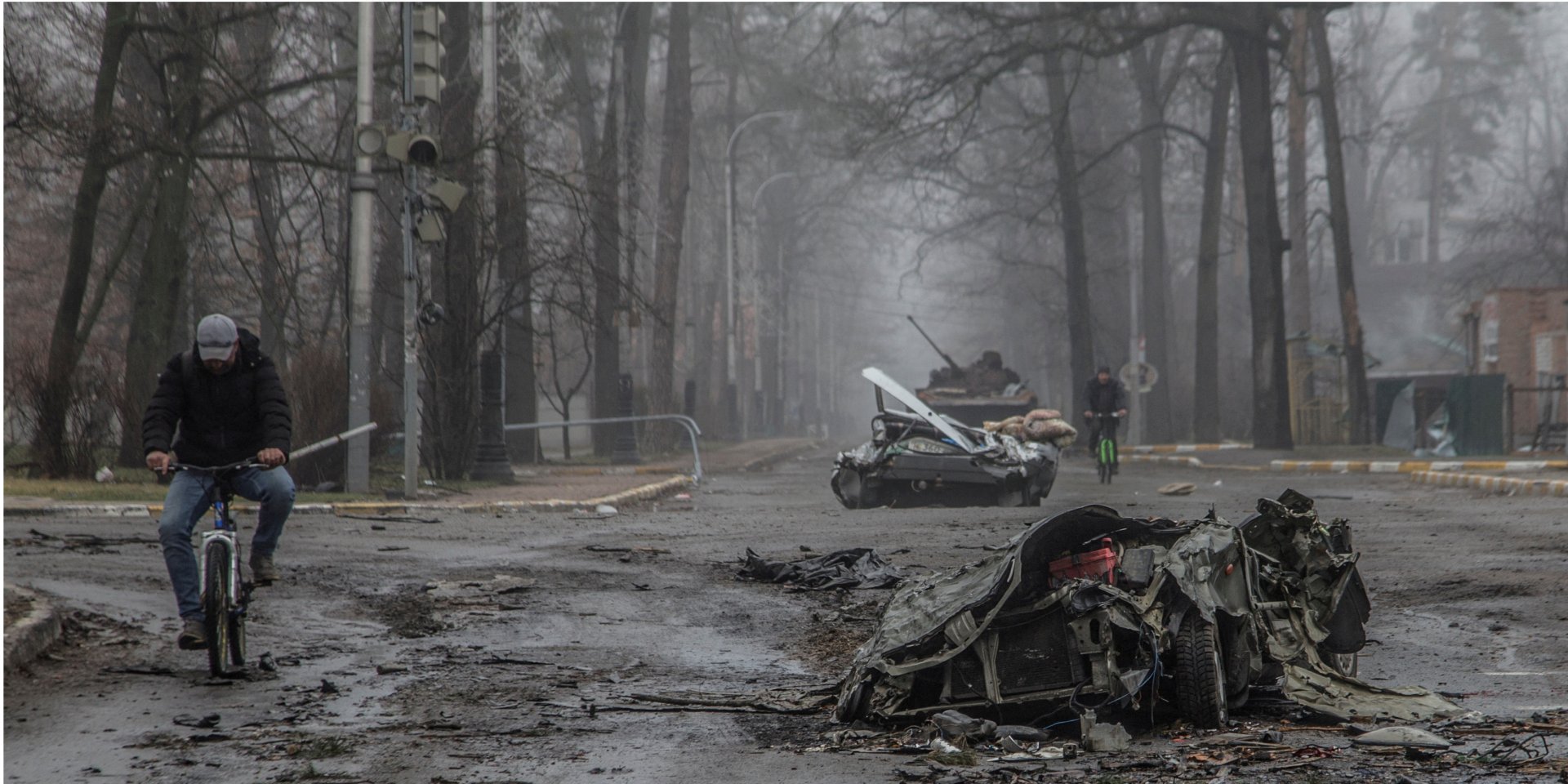 A resident of Bucha, Kyiv Oblast, rides a bike next to a destroyed Russian tank. (Photo: REUTERS/Oleksandr Ratushniak)