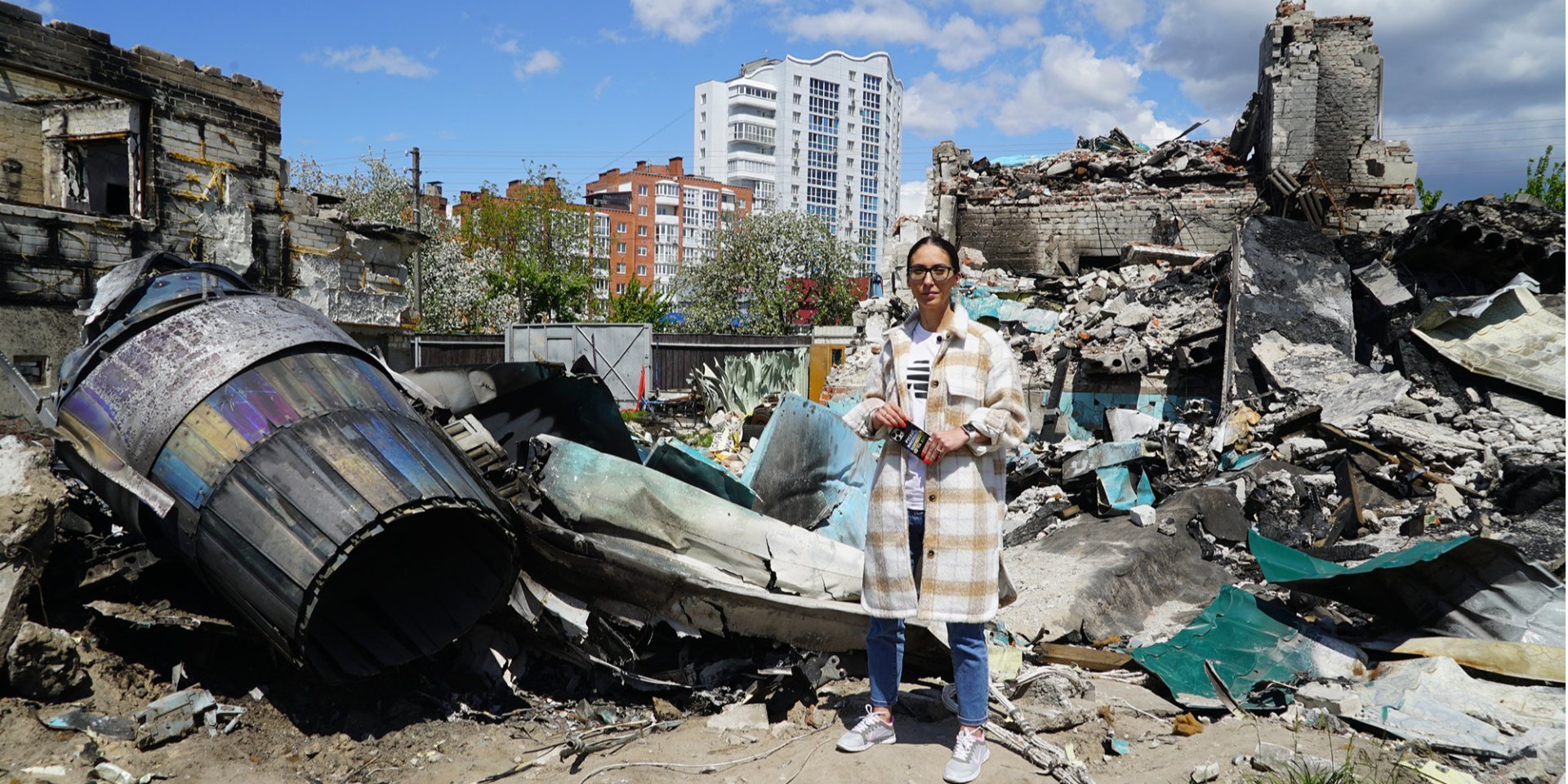 Yulia Grebneva stands near the ruins of her house and the wreckage of an enemy plane, which still remains in the yard (Photo: Kristina Berdynskikh/ НВ)