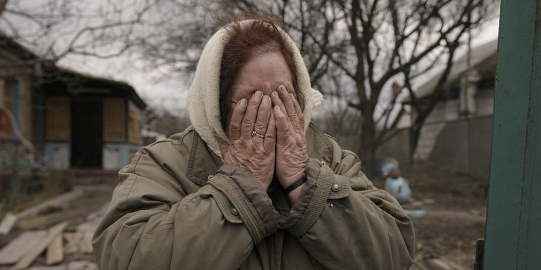 Татьяна Алексеенко плачет, стоя у ворот своего дома в селе Андреевка (Фото: AP Photo/Вадим Гирда)
