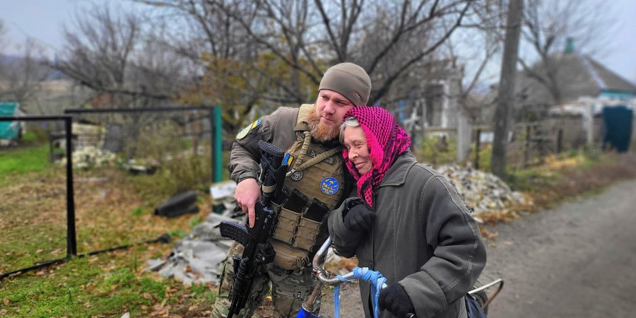 Військовослужбовець ЗСУ Євген втішає жительку села Шандриголове Лиманського району, яка показує свій зруйнований будинок (Фото:НВ)