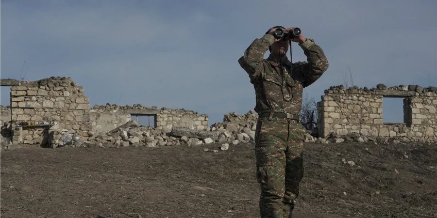 An Armenian soldier looks through binoculars at a combat position near the village of Taghavard in Karabakh, January 2021 (Photo: Artem Mikryukov / REUTERS)