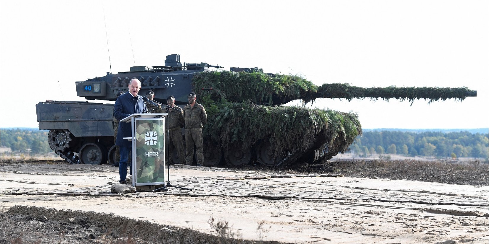 German Chancellor Olaf Scholz speaks against the backdrop of a Leopard 2 tank at the Bundeswehr military base in Bremen, October 2022 (Photo: REUTERS/Fabian Bimmer/File Photo)