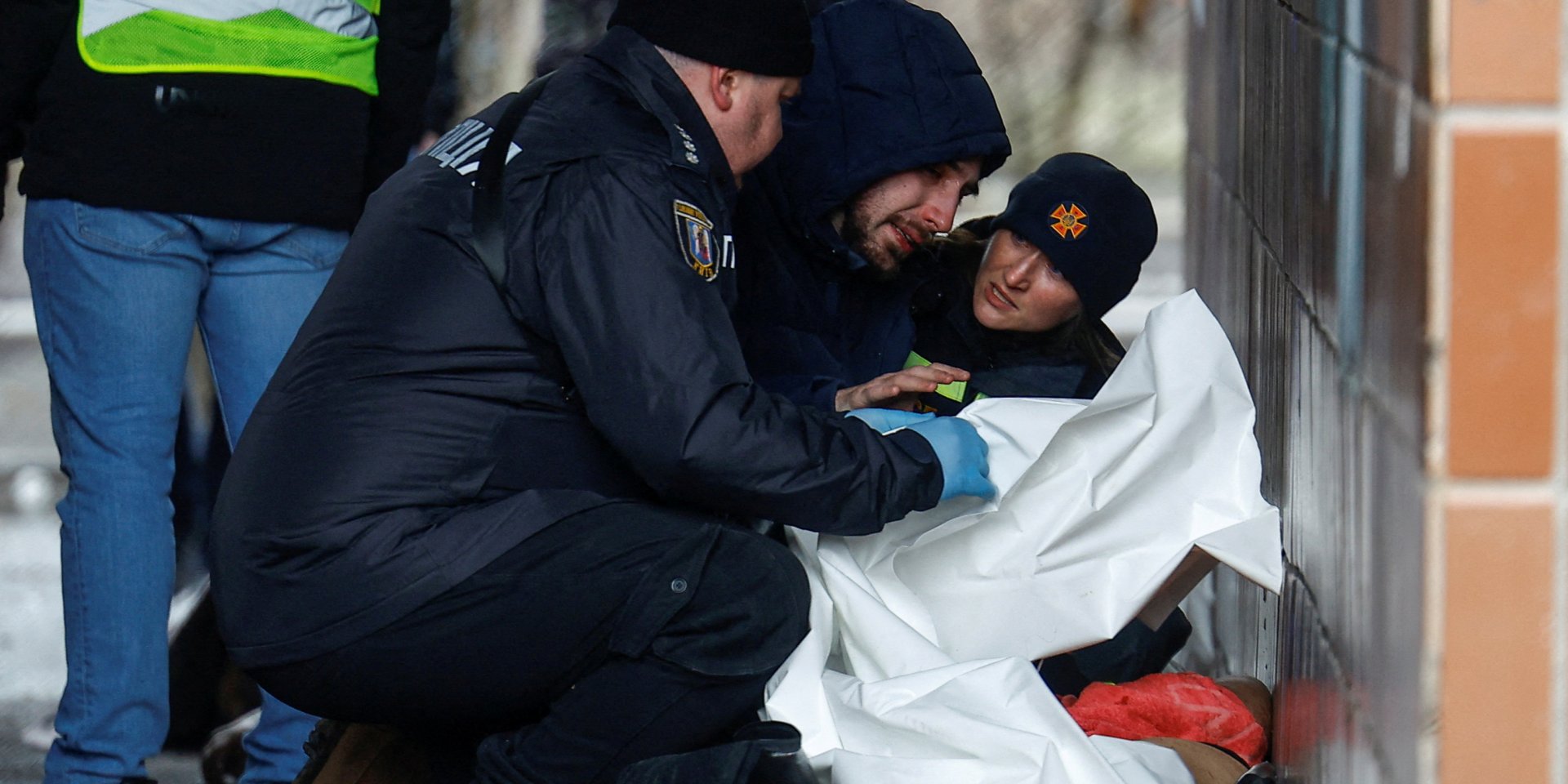 Specialists of the State Emergency Service and the National Police near a man who found a loved one among the dead in Kyiv, February 7, 2024 (Photo: REUTERS/Valentyn Ogirenko)