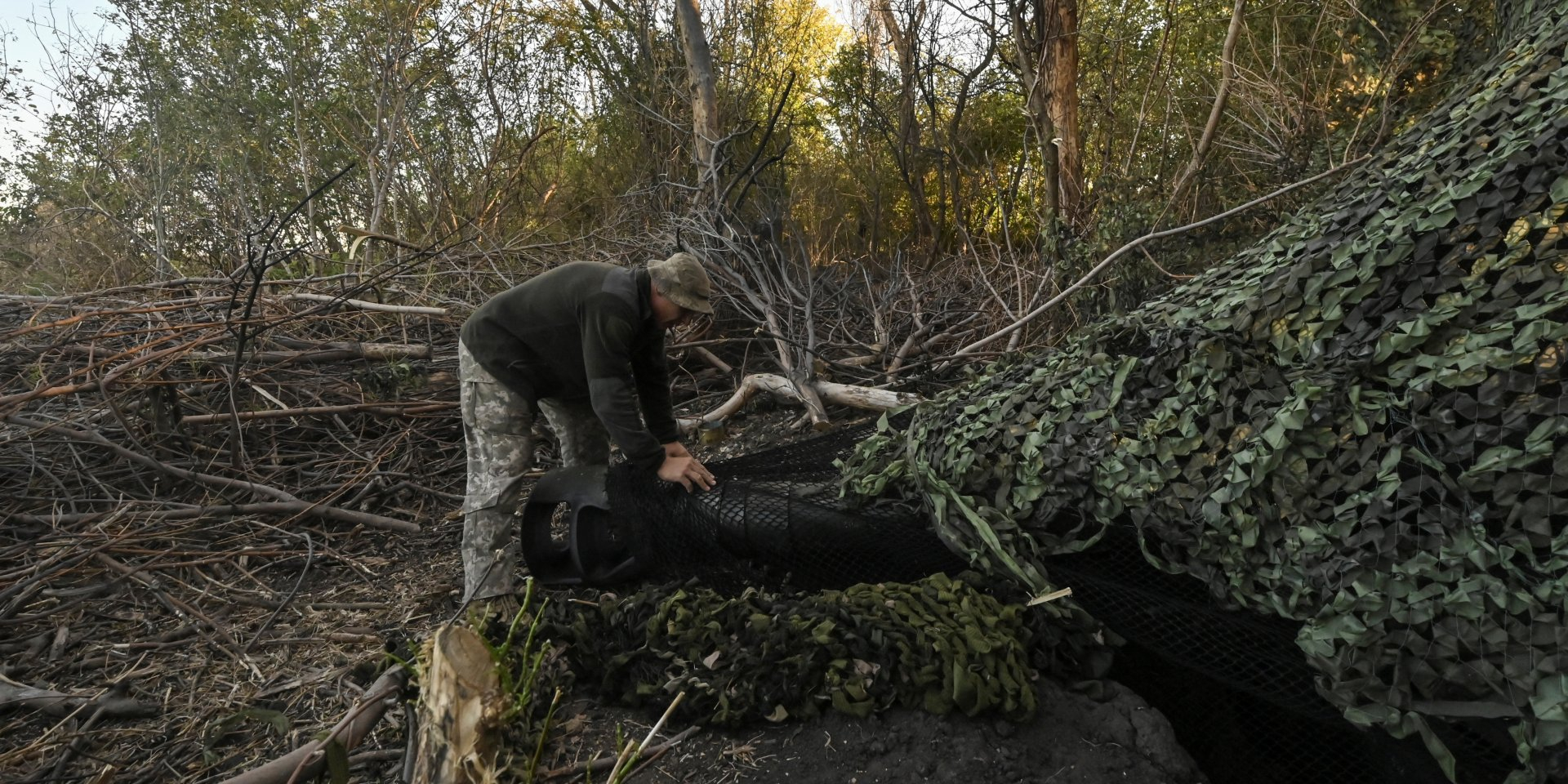 A Ukrainian military man covers an AS90 self-propelled gun with a net, September 24, 2024 (Photo: REUTERS/Stringer)