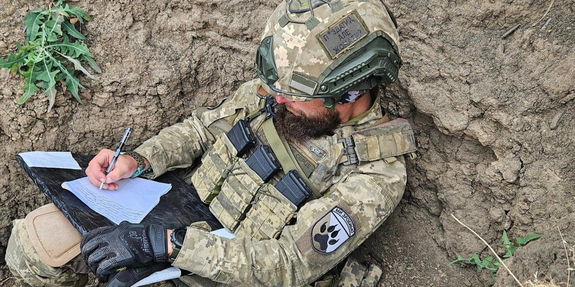 Боец 118 отдельной механизированной бригада пишет диктант в окопе (Фото: @118 отдельная механизированная бригада/Facebook)