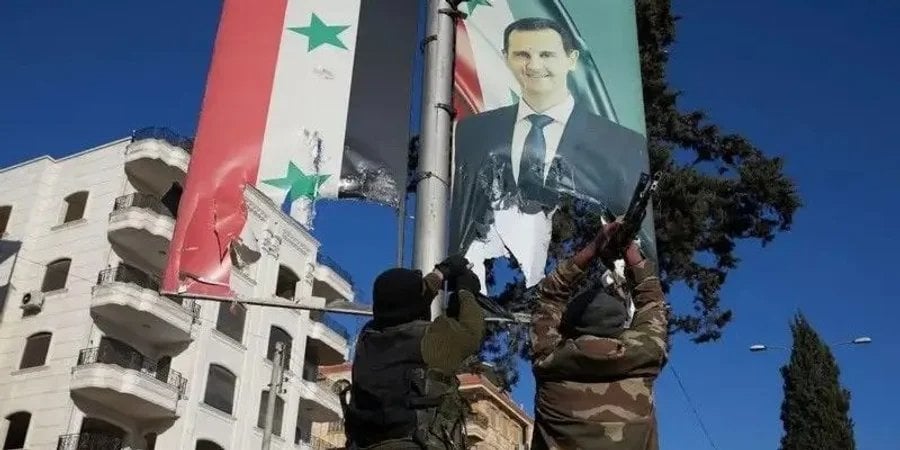 Повстанцы в центре Алеппо снимают портрет президента Башара Асада (Фото: EPA)