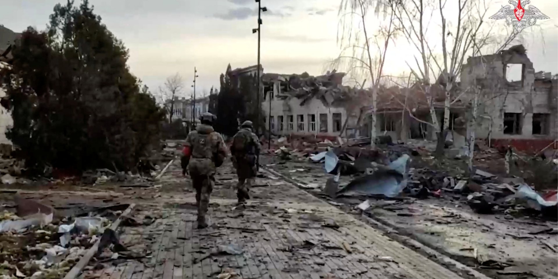Российские военнослужащие якобы проходят мимо разрушенного здания в городе Суджа, которое недавно отбили российские вооруженные силы. Курская область, 15 марта (Фото: Russian Defence Ministry/Handout via REUTERS)