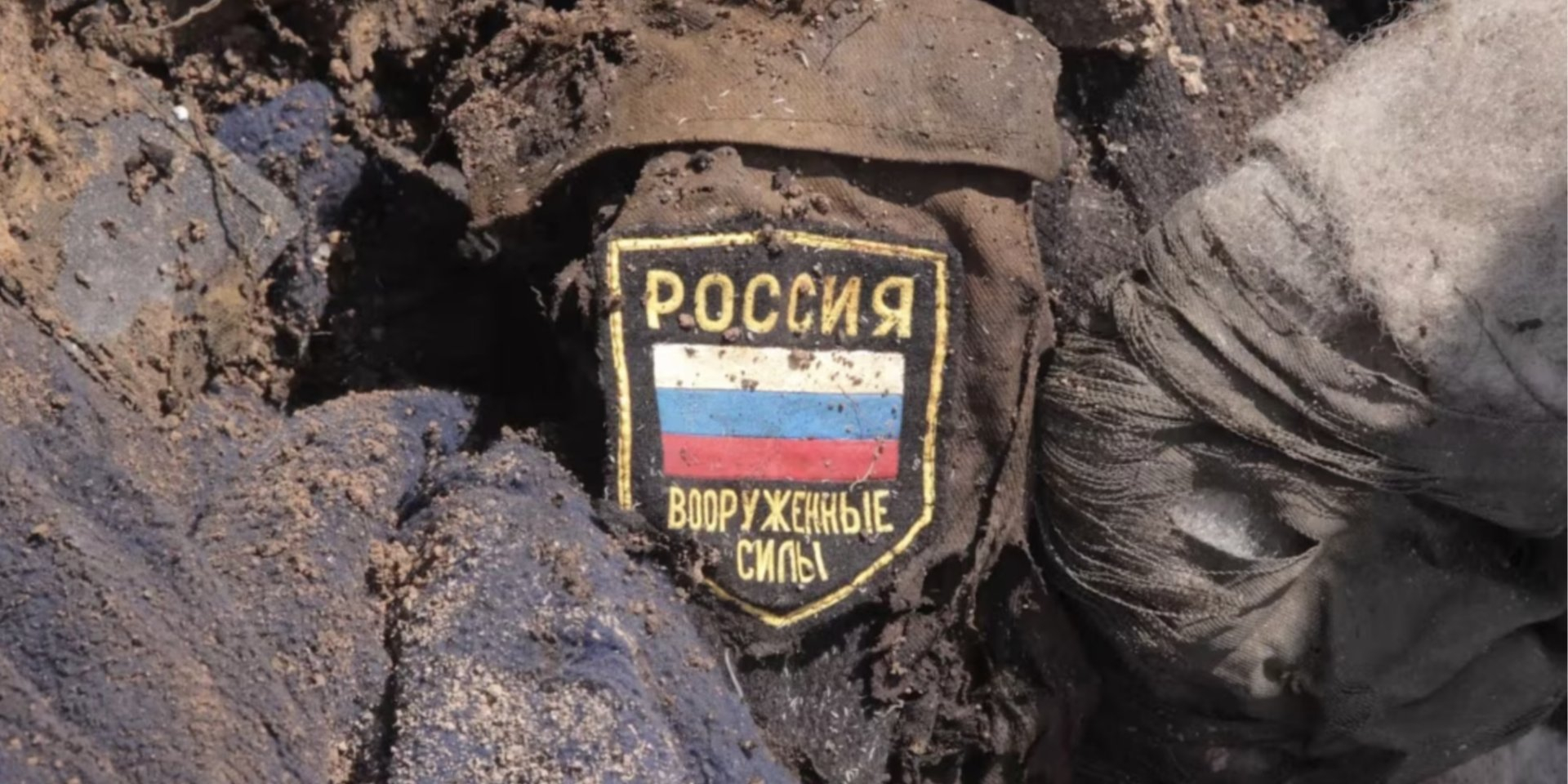 Russian occupier’s uniform and chevron buried in the ground, illustrative photo (Photo: RFE/RL)