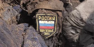 Russian occupier’s uniform and chevron buried in the ground, illustrative photo (Photo: RFE/RL)