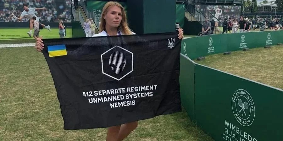Олександра Олійникова з прапором 412 бригади Nemesis, де служить її тато (Фото: instagram.com/_drones4ua.org)