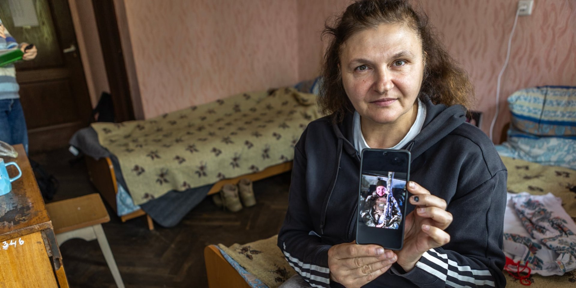 Олена Яковлєва показує фотографію себе на фронті з улюбленою гвинтівкою (Фото: Олександр Медведєв)