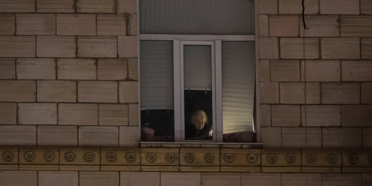 A woman looks out a window during a power outage following recent Russian missile and drone attacks on critical civilian infrastructure in Kyiv, Ukraine, Jan. 15, 2026. (Photo: REUTERS/Gleb Garanich)