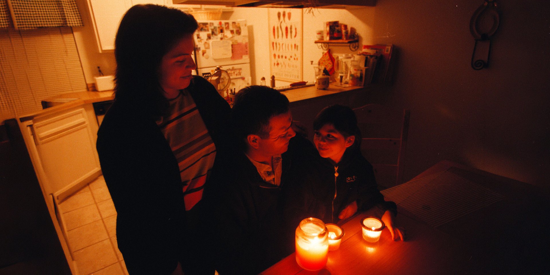 Педро Саенс його дружина Крістін та 4-річна донька Стефані економлять електроенергію, запалюючи свічки та тепло одягаючись, щоб заощадити електроенергію під час енергетичної кризи в Каліфорнії, 4 січня 2001 року (Фото: Sandy Huffaker/ZUMAPRESS via Reuters)