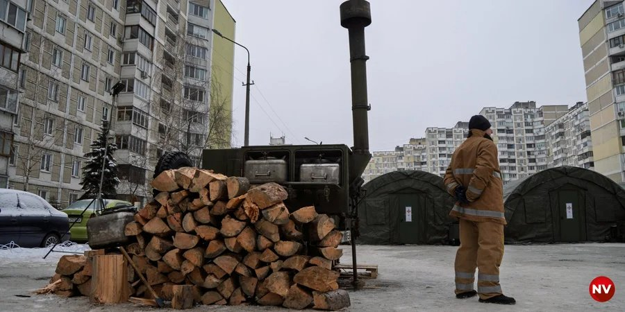 A State Emergency Service worker stands in front of a deployed tent camp in Kyiv’s Troieshchyna district (Photo: Serhii Okuniev, NV)