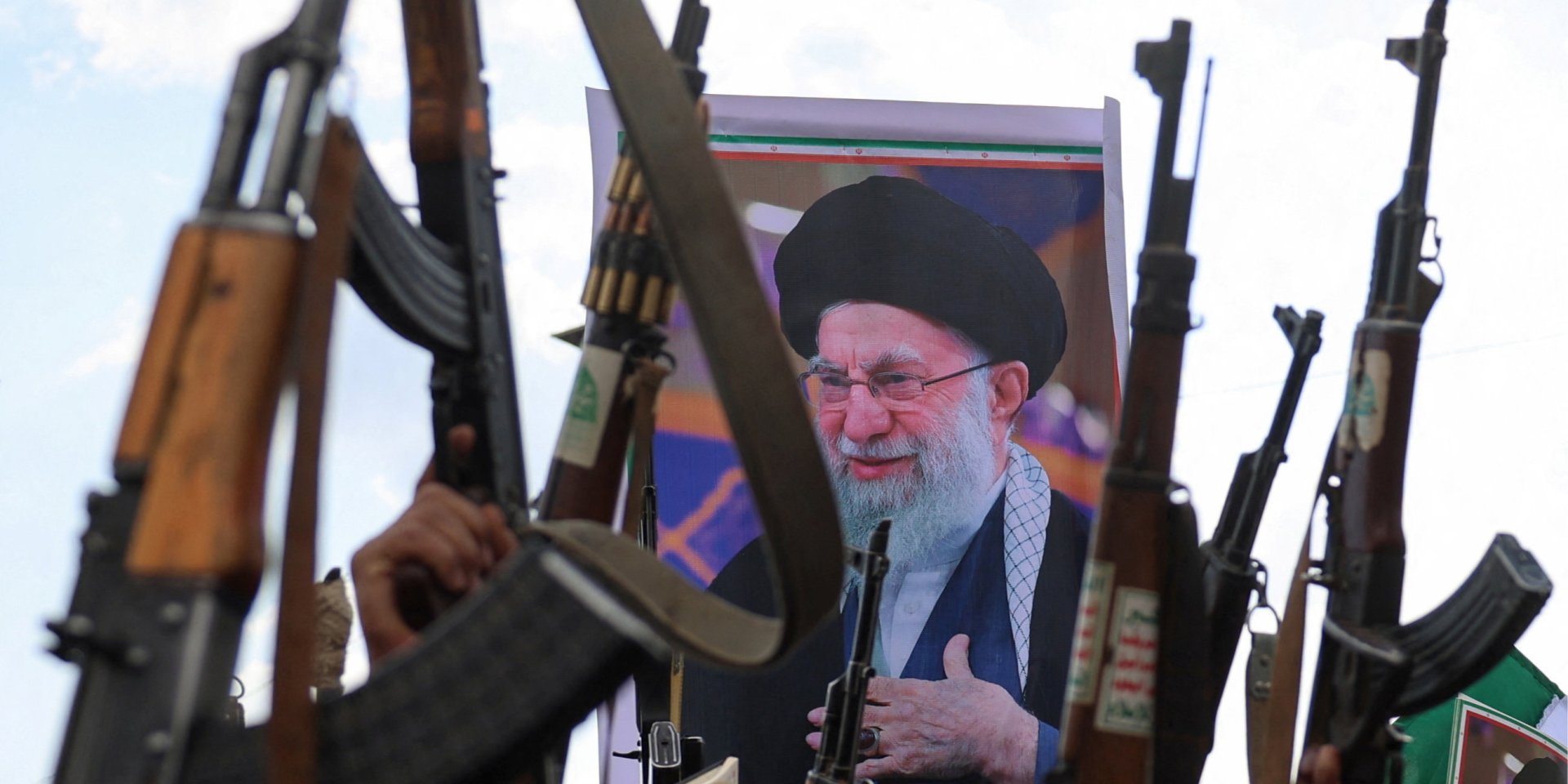 Іранці тримають зброю на тлі портрета ліквідованого Алі Хаменеї (Фото: REUTERS/Khaled Abdullah)