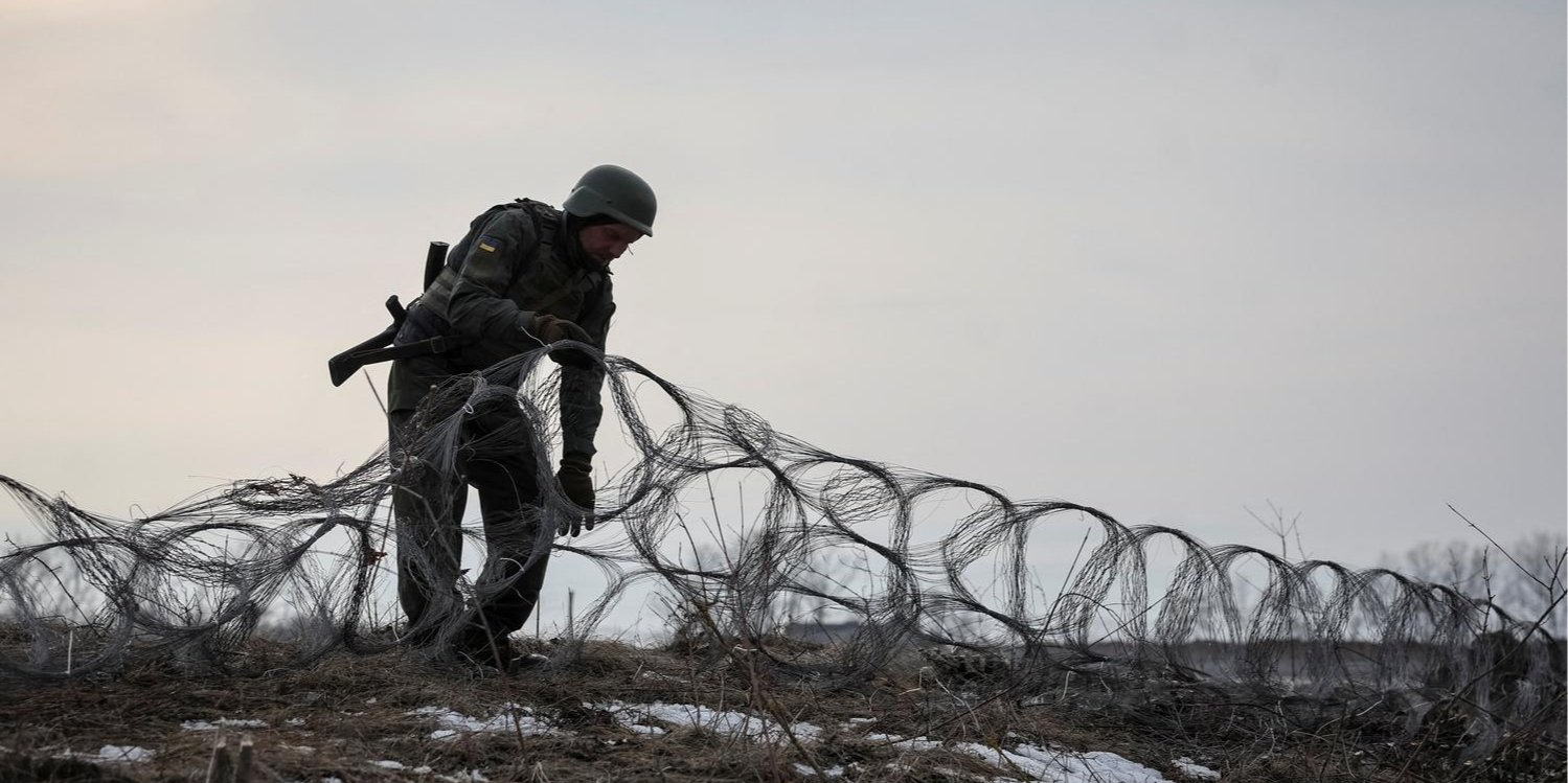 A Ukrainian service member installs low-visibility wire obstacles on the front line near Kupyansk. (Photo: Radio Free Europe/Radio Liberty/Serhii Nuzhnenko via Reuters)