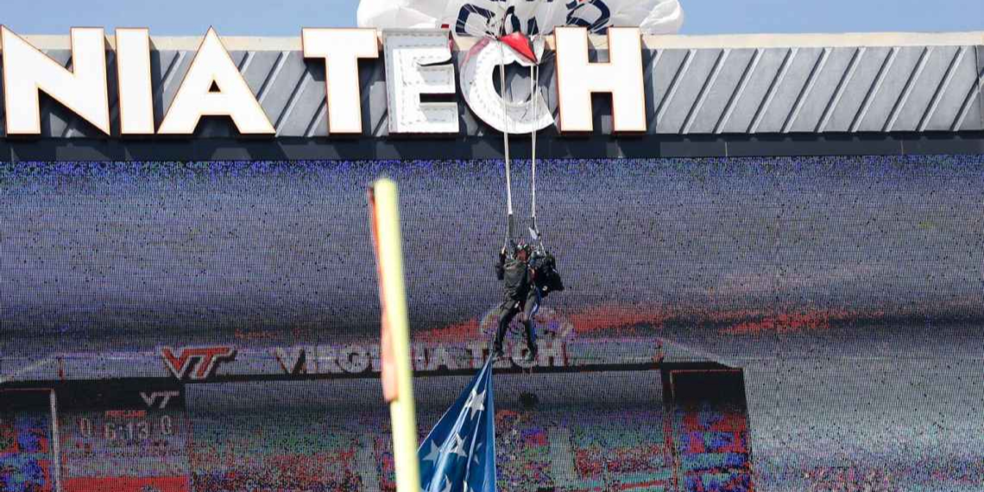 Повис на буквах. В США парашютист врезался в табло во время футбольного матча и остановил игру — видео