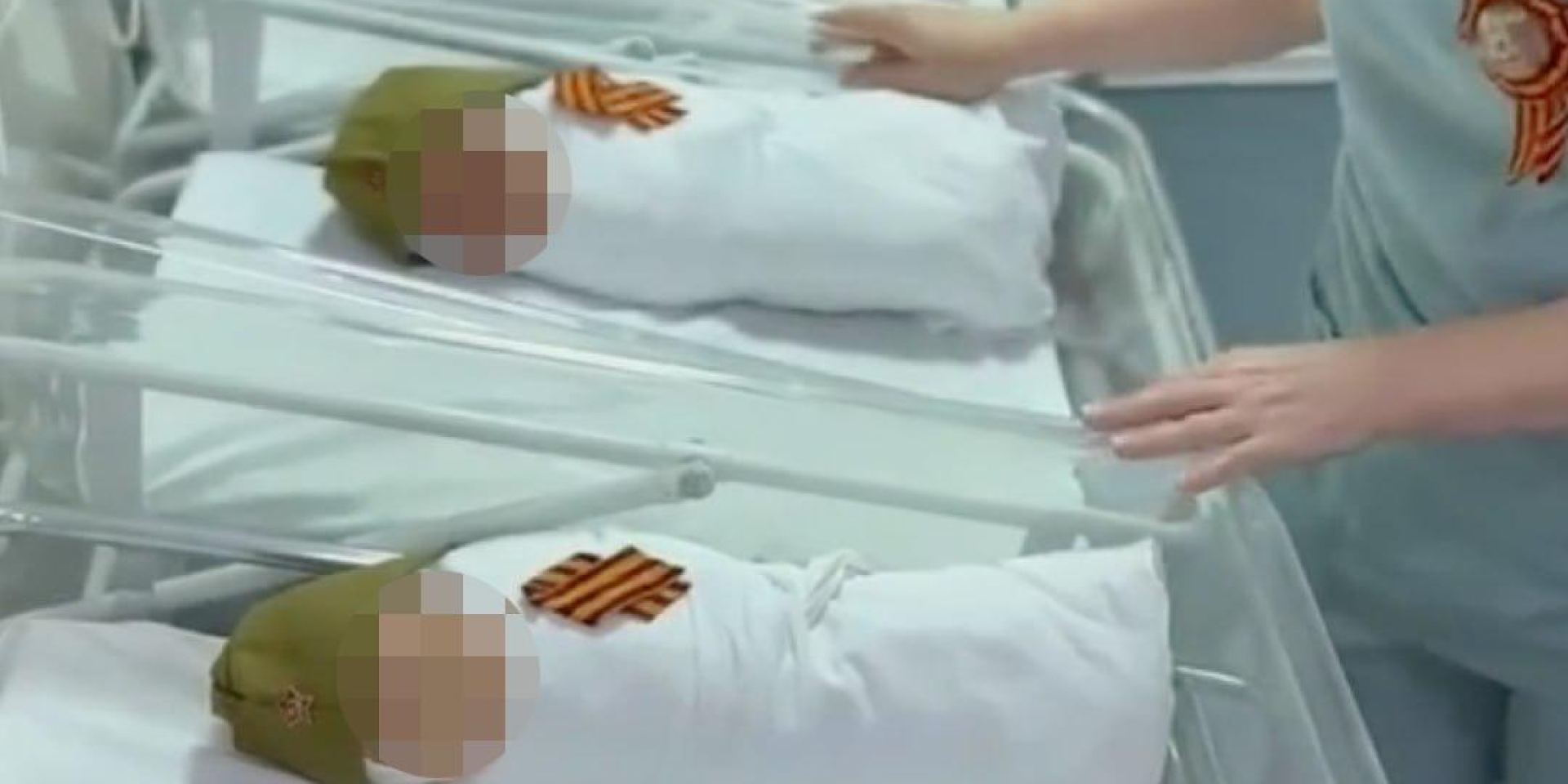 Russian newborns dressed in military caps and ribbons
