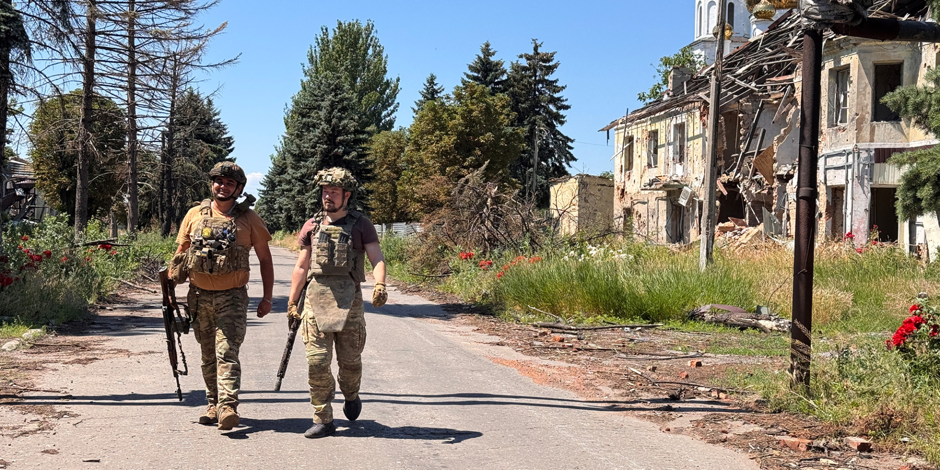 Ukrainian servicemen in full gear walk along a road past a building destroyed by shelling in Donetsk Oblast (Photo: Alex Nikitenko/Global Images Ukraine via Getty Images)