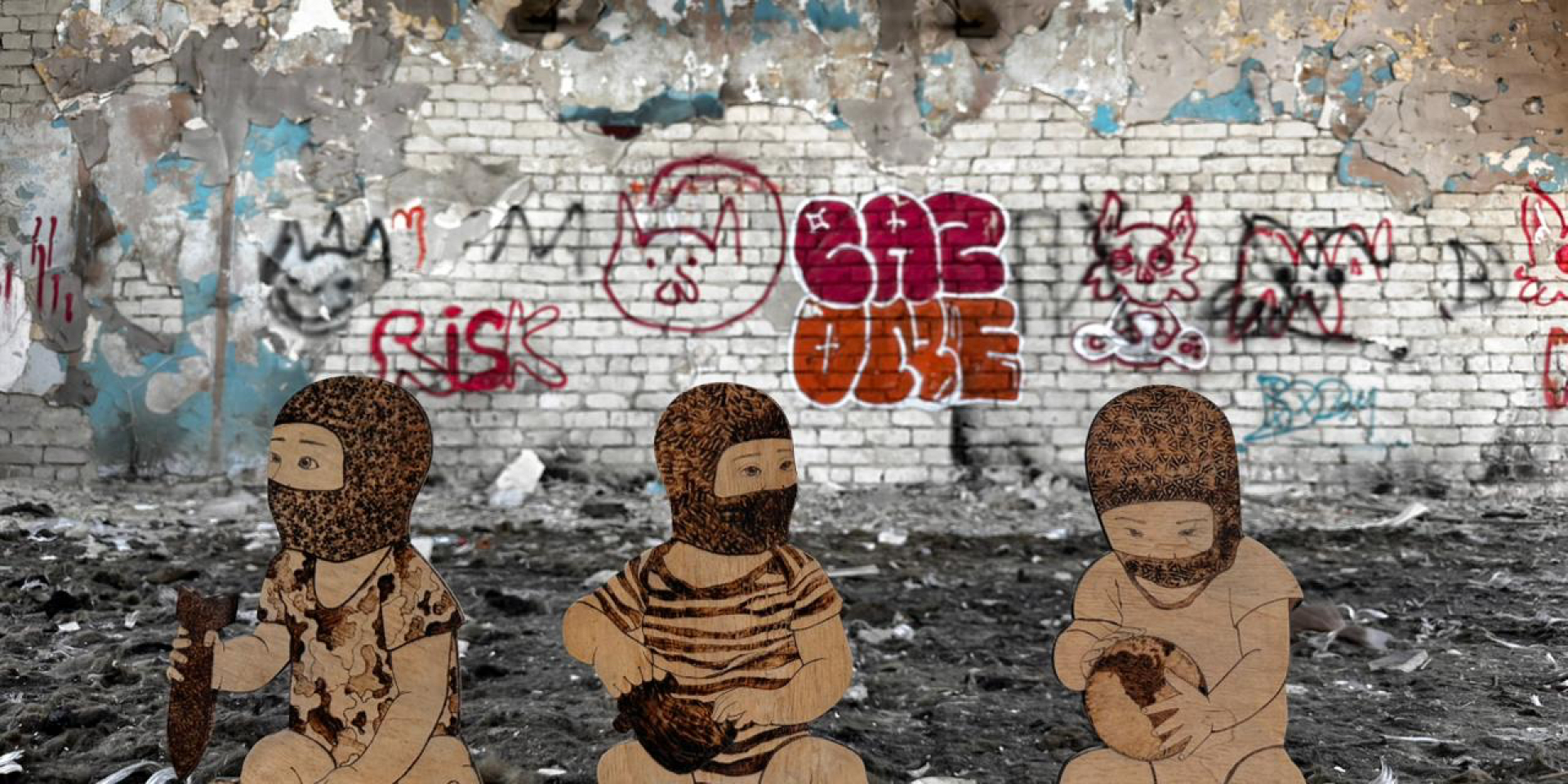 Three wooden figures from the Cradle of War project during the first intervention in the destroyed gymnasium No. 134 in Kharkiv (Photo: Oksana Solop’s Cradle of War confronts memory, violence and the future)