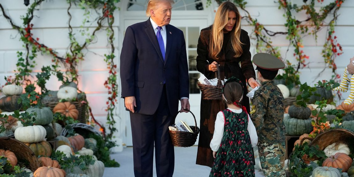 Donald and Melania Trump hand out candy to a girl wearing a traditional Russian headdress and a boy clad in a military uniform with a Soviet-style peaked cap (Photo: REUTERS/Eric Lee)