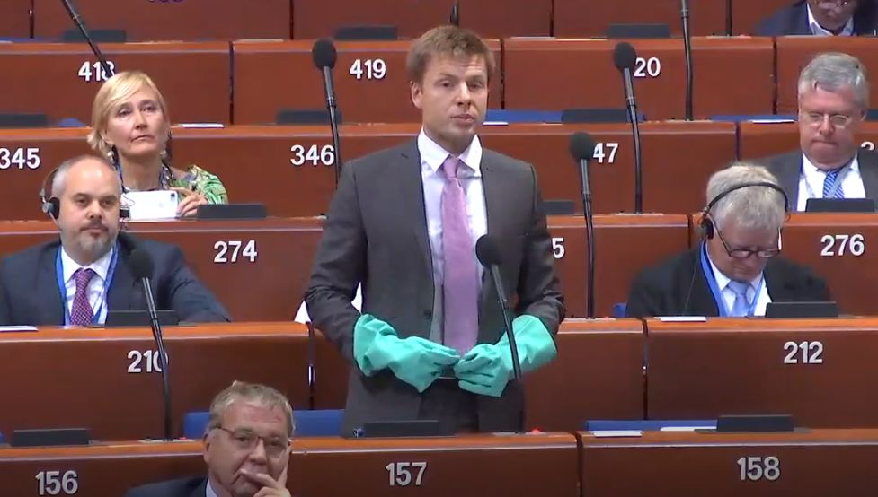 Народний депутат України Олексій Гончаренко під час дебатів у ПАРЄ вдягнув гумові рукавиці (Фото: скріншот)