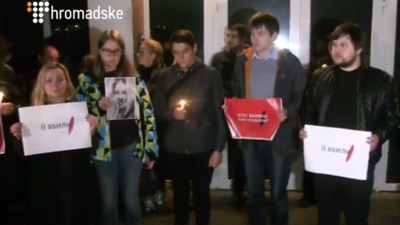  Собравшиеся держат плакаты с надписями 