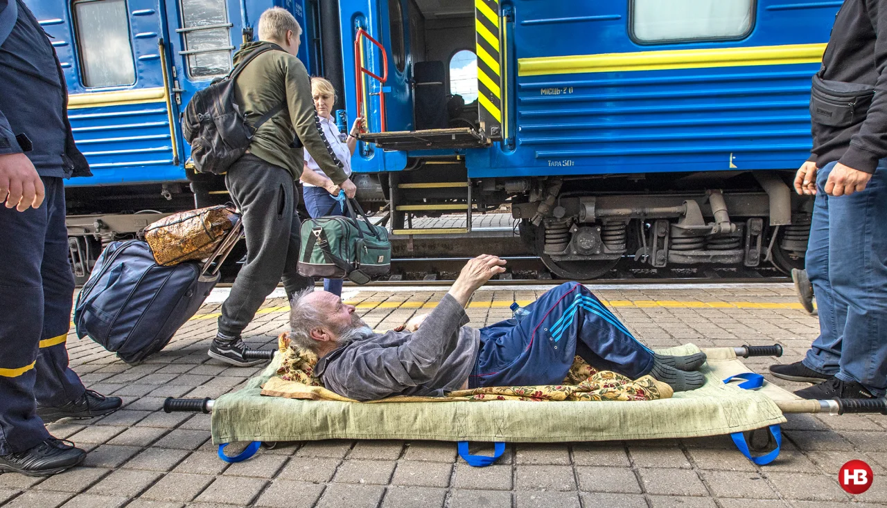 У пенсіонера Івана (на ношах) за кілька місяців до війни померла дружина. Він лишився сам і пересуватися самостійно не може (Фото: Олександр Медведєв / НВ)