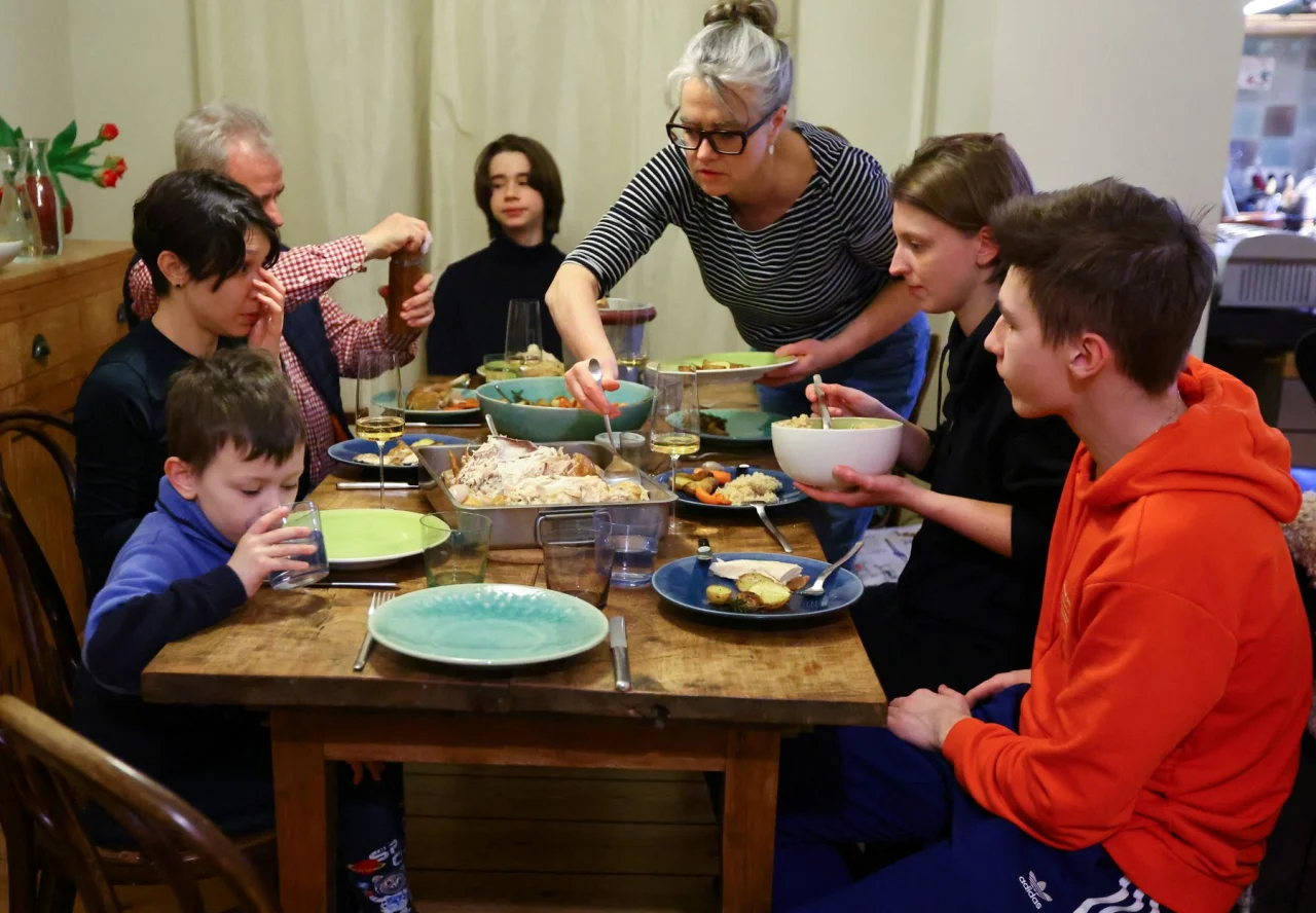 Українські біженці обідають разом із родиною, що прихистила їх у своєму помешканні в Берліні, Німеччина (Фото: Fabrizio Bensch / REUTERS)