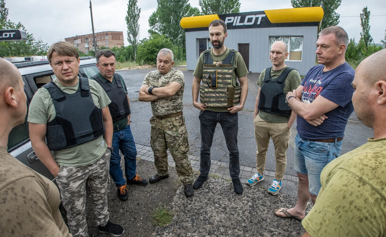 Депутат СН Андрей Герус (на фото слева), советник главы ОП Сергей Лещенко (в центре) общаются с военными, которым привезли пикап (Фото: Александр Медведев / НВ)