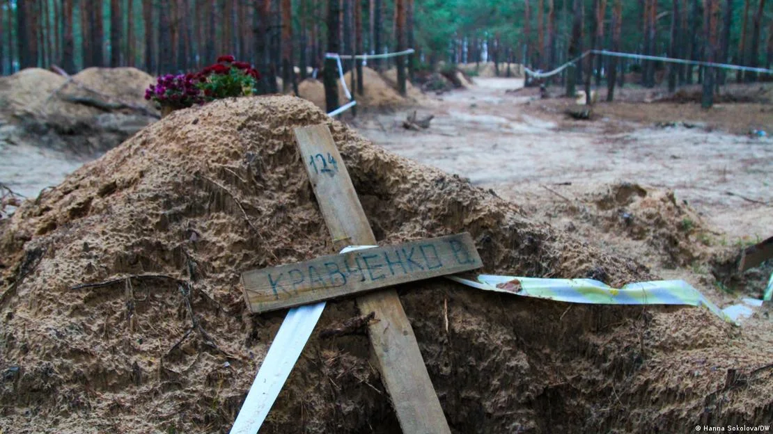 Живі квіти біля порожніх могил в Ізюмі (Фото: Ганна Соколова / DW)