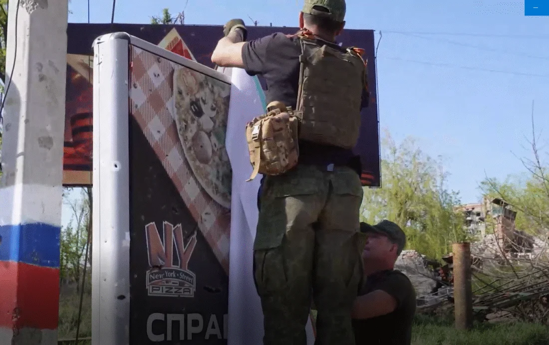 Окупанти чіпляють свої плакати на старих вивісках (Фото: Росджерела)