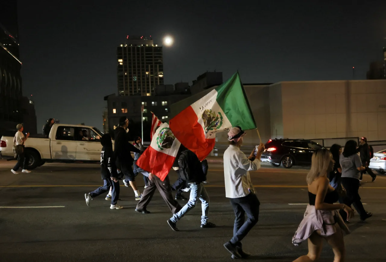 Демонстранты идут по улице в центре Лос-Анджелеса после начала комендантского часа на фоне протестов против антимиграционных мер властей США, 10 июня 2025 (Фото: REUTERS/Leah Millis)