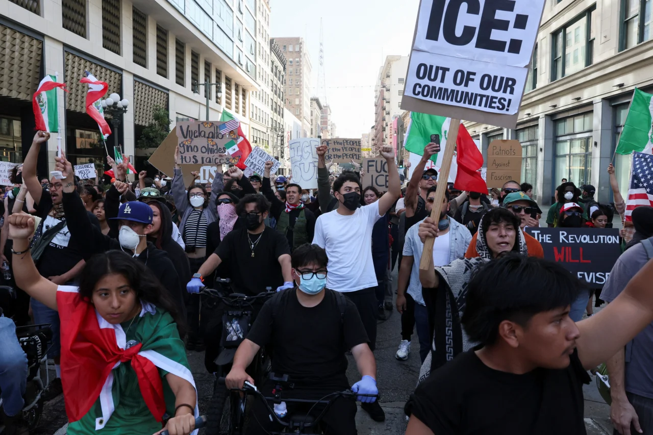 Демонстранты держат плакаты и флаги, включая призывы против ICE (Миграционной и таможенной правоохранительной службы США) во время протестов в центре Лос-Анджелеса, Калифорния, США, 10 июня 2025 (Фото: REUTERS/Leah Millis)