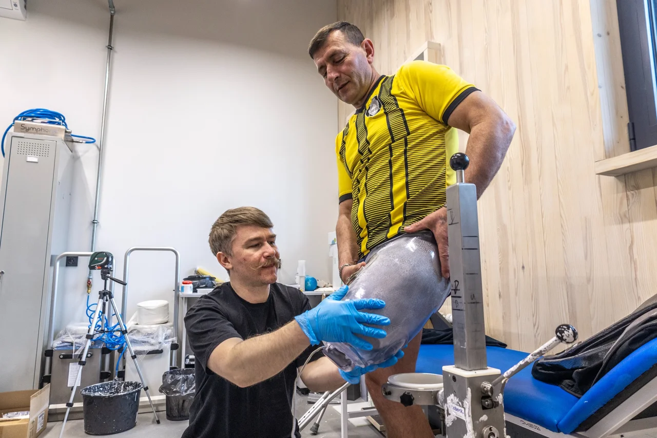 Протезист Остап Попович помогает военному Анатолию Ковалеву надеть на культю прозрачную гильзу для установки протеза (Фото: Александр Медведев)