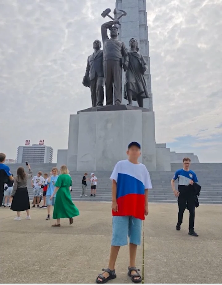 Михайло на фоні монумента, збудованого на честь Кім Ір Сена (Фото: Скриншот із сюжету пропагандистського телеканалу)